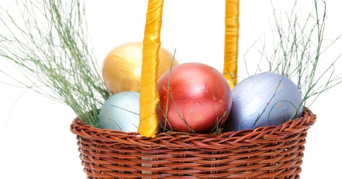 Colorful painted easter eggs in basket on white
