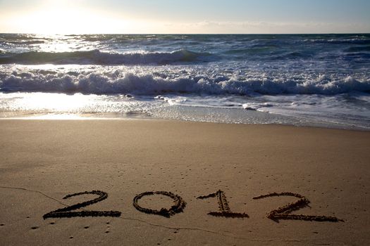 2012 written on the beach horizontal with waves