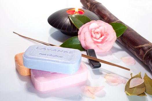 Incense, flower and soap on white