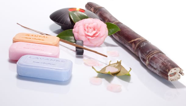 Incense, flower and soap on white