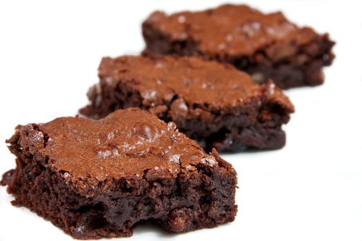 Three pieces of homemade brownie cake isolated on white background.