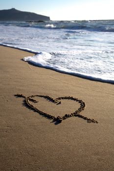 Valentine's Day heart with cross on the beach 
