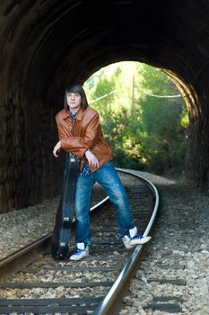 Cool guitarist portrayed inside a railway tunnel