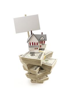 Small House on Stacks of Hundred Dollar Bills and Blank Sign Isolated on a White Background.