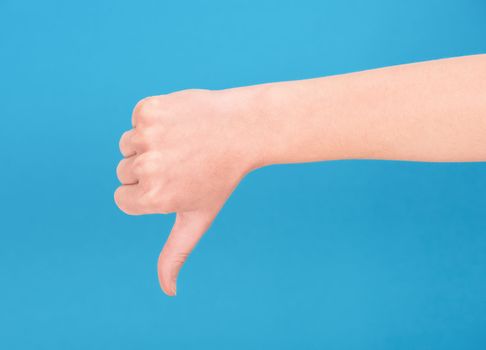 Right hand showing thumb down on blue background