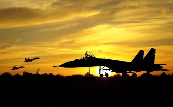 Military aircrafts silhouettes  on sunset background