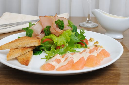Salad mix with cherry tomatoes and ham with, toast with grapefruit cream sauce