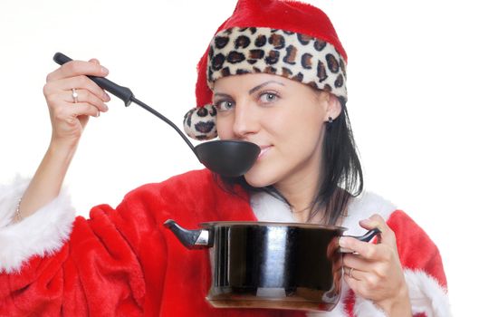 Pretty woman cooking the soup in Santa Claus dress