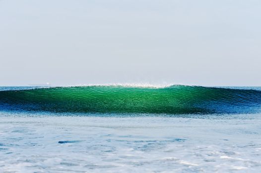 High blue-green sea wave on the background sky