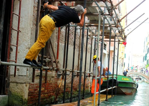 builders repair a house in Venice. Building forests straight from water