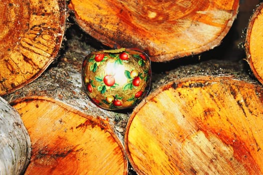 Christmas apple lying in a beautifully roled firewood