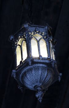 Beautiful latern in the winter landscape of dark metal