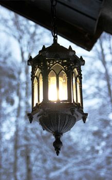 Beautiful latern in the winter landscape of dark metal