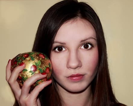 Girl with a New Year's apple. brown eyes, brown hair