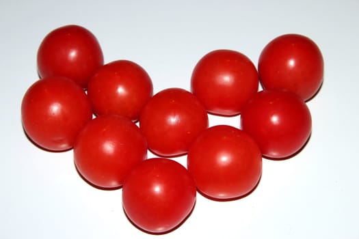 Heart from  little tomatoes isolated on white background