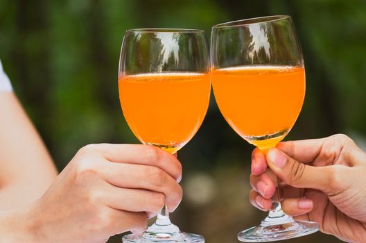 Glass of orange juice celebrate on green background