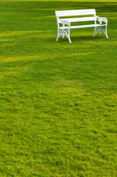 Long white bench in the park on a beautiful lawn