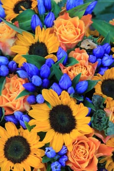 Flower arrangement with big yellow sunflowers and blue flowers