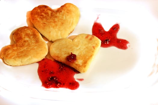 Cheese pancakes in form hearts.with arrow from srawberry jam Isolated on white background. Love