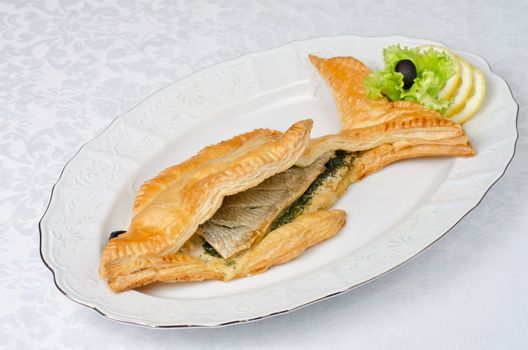 tasty dish of trout fish baked with greens at dough