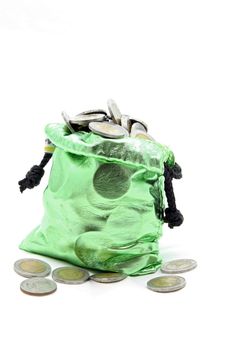 full coins spilling out from green money bag or purse isolated on white