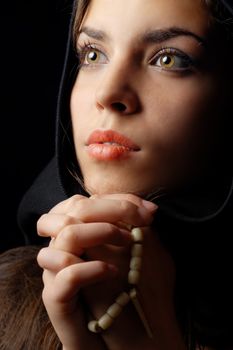 Photo of praying woman in black hood