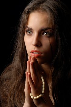 Praying of repentant woman with religious string of beads