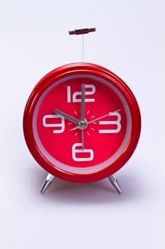 close up of red clock face on white background in portrait orientation