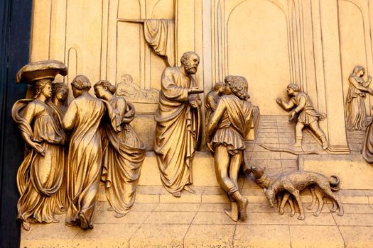 A bronze people and dogs on the church door
