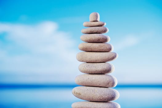 Balancing white pebbles each other on a sky background