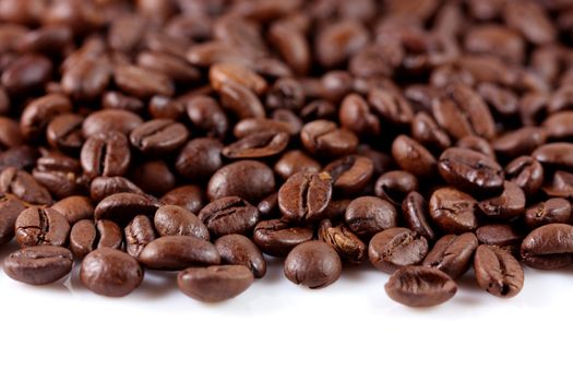 A pile of coffee beans forming a border on a white background
