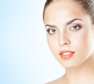 Close-up portrait of the beautiful woman with perfect makeup on a blue background