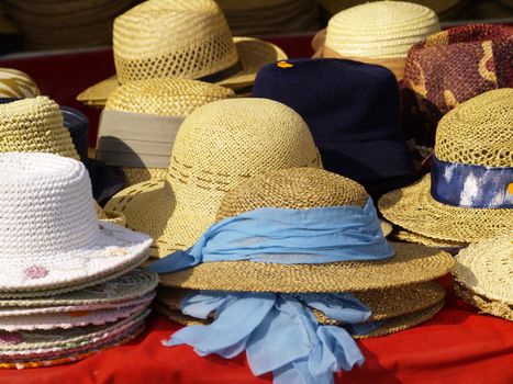 selection of straw hats on market stand