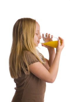 A girl drinking a tall glass of orange juice