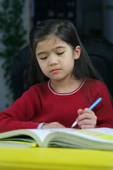 Six year old girl doing her homework at night.