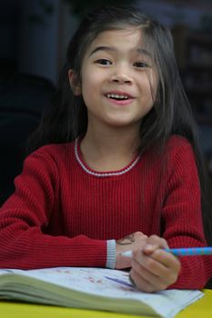 Six year old girl doing her homework at night.