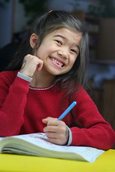 Six year old girl doing her homework at night.