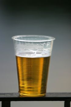 Plastic glass with beer on a dim background