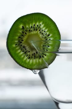 Glass with a plate kiwi on a dim background