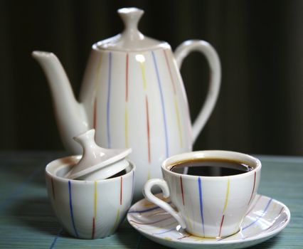 Two cups and a teapot on a green wooden napkin