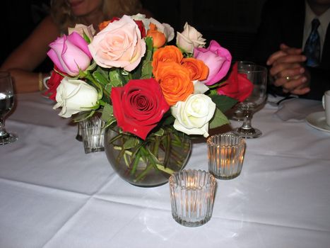 A nice arrangement of colorful roses on a table at an anniversary reception.