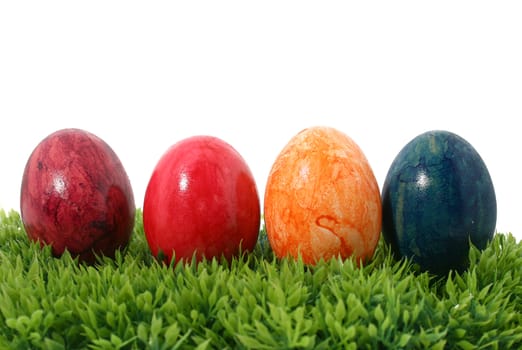 four eastereggs on green grass isolated on white background