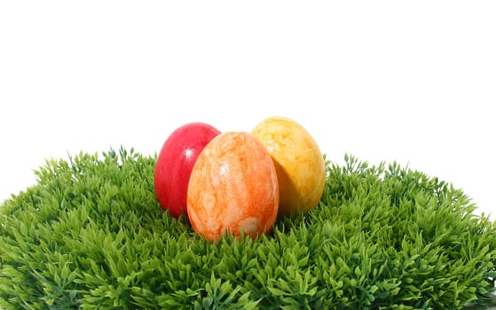 three eastereggs on green grass isolated on white background