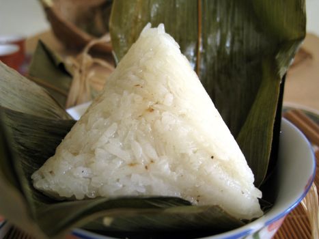 a pyramid-shaped mass of glutinous rice wrapped in leaves, special food for the Dragon Boat Festival (falling on the fifth day of the fifth lunar month), one culture occasion in Chinese