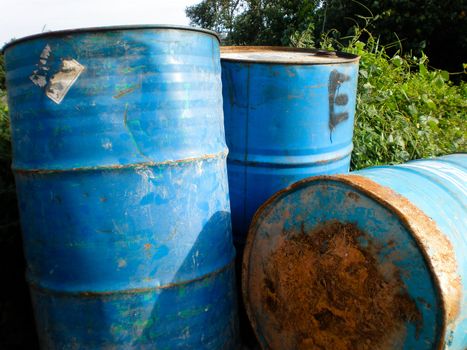 Rusty and stained steel barrels in the open