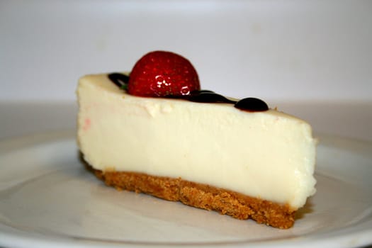 Close up of a strawberry cheesecake on a plate.