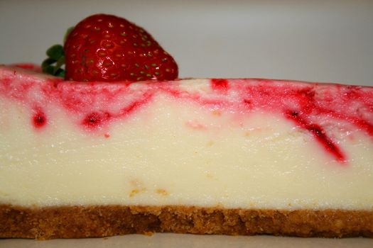 Close up of a strawberry cheesecake on a plate.
