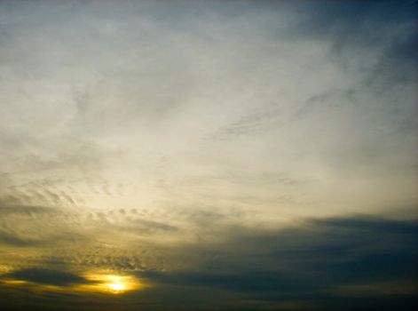 Cloudy sky with sun shinning at a distance