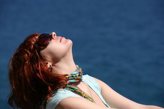 The woman with red hair enjoys the sun
