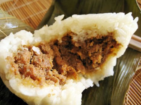 a pyramid-shaped mass of glutinous rice wrapped in leaves, special food for the Dragon Boat Festival (falling on the fifth day of the fifth lunar month), one culture occasion in Chinese